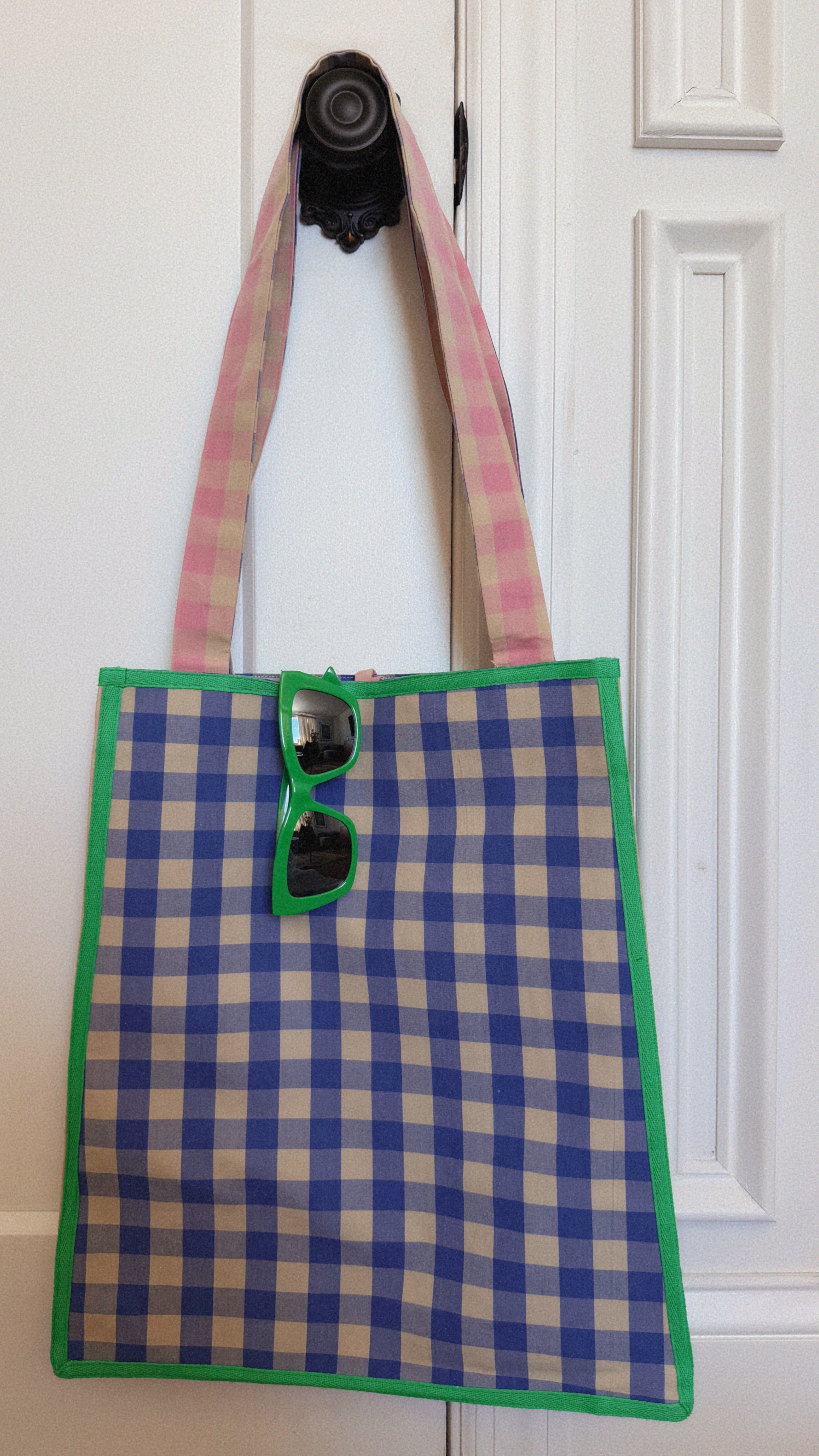 Plaid tote bag with a camera on a white background. Maderas Gingham Tote Bag