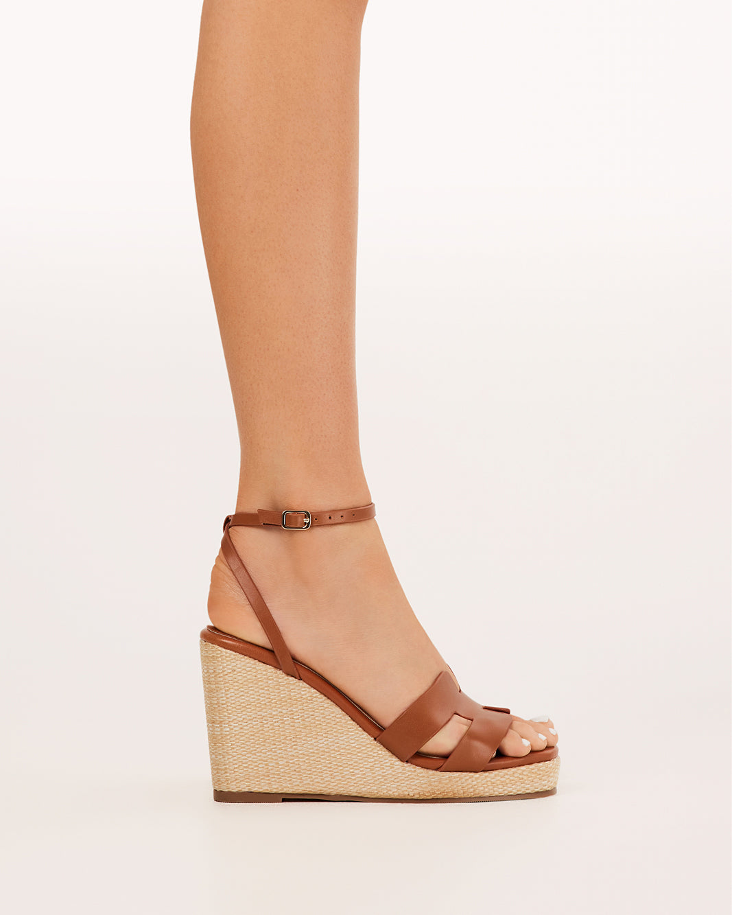 Billini Delphinia Tan Wedge Sandals. Brown wedge sandal on a light beige background
