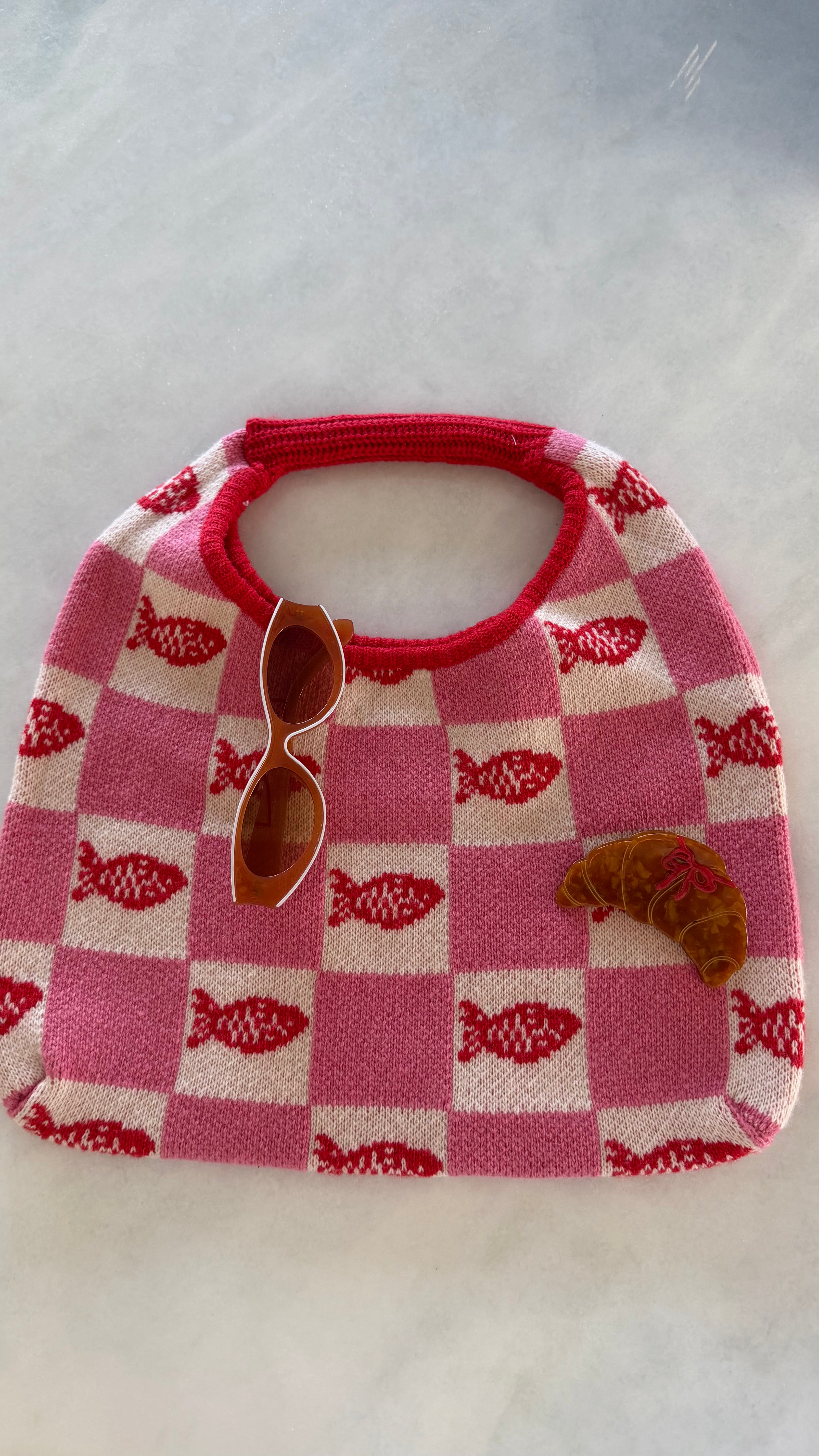 FRNCH Tulum Bag. Checkered bib with fish pattern and sunglasses on a light gray background