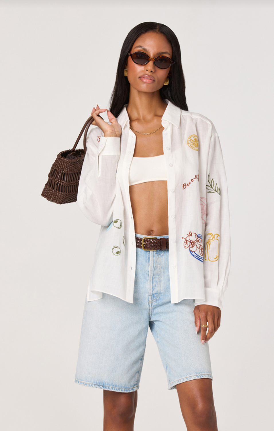 ASTR the Label Trace White Picnic Shirt. Woman wearing a white embroidered blazer, white top, light blue shorts, and brown sandals on a white background.