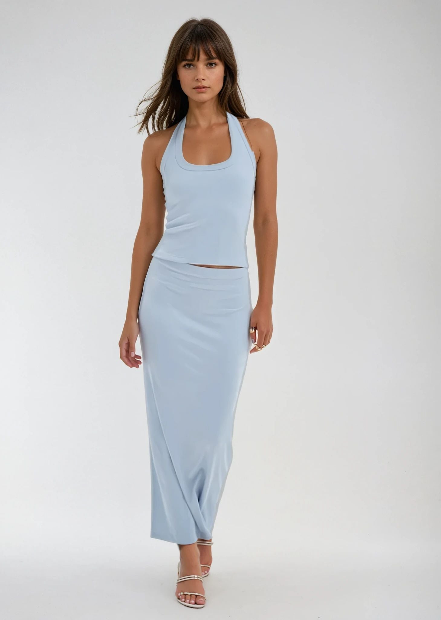 Woman wearing a light blue sleeveless top and high-waisted skirt on a white background. LNA Slater Blue Mist Skirt