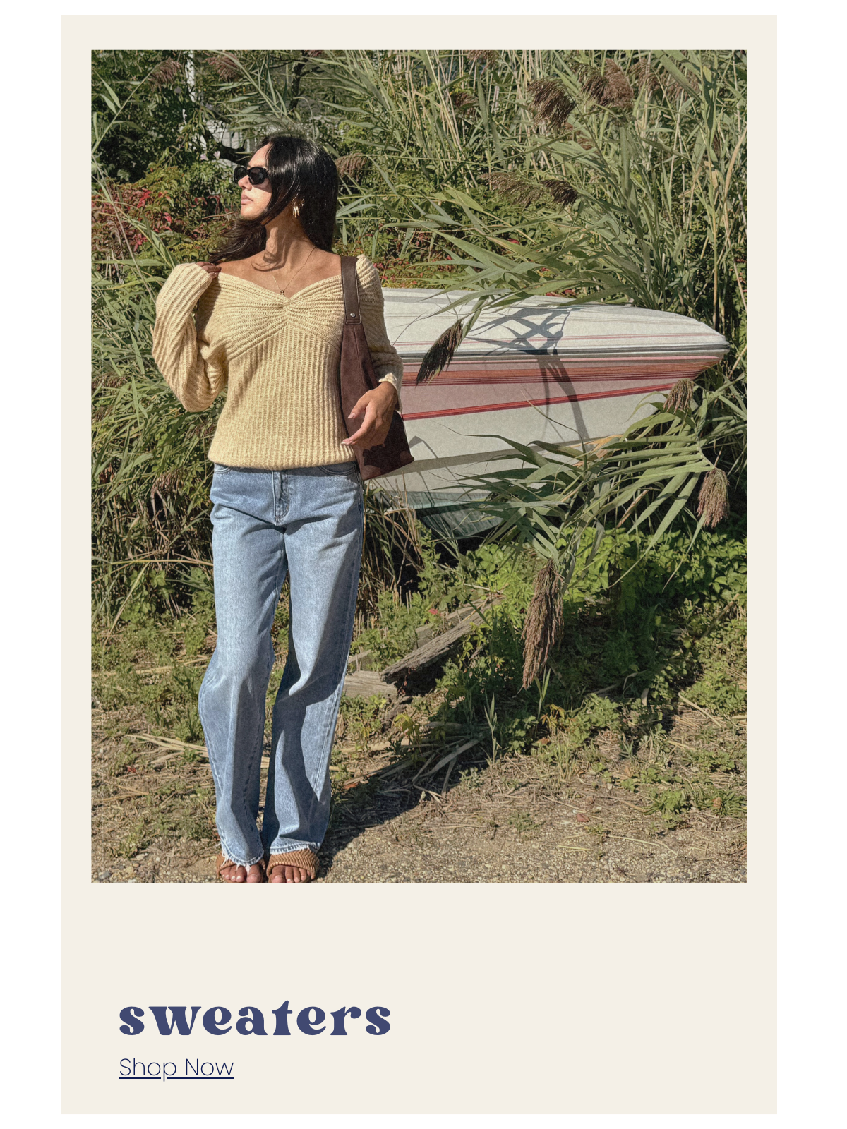Woman holding a surfboard with text overlay 'sweaters' and 'Shop Now'.