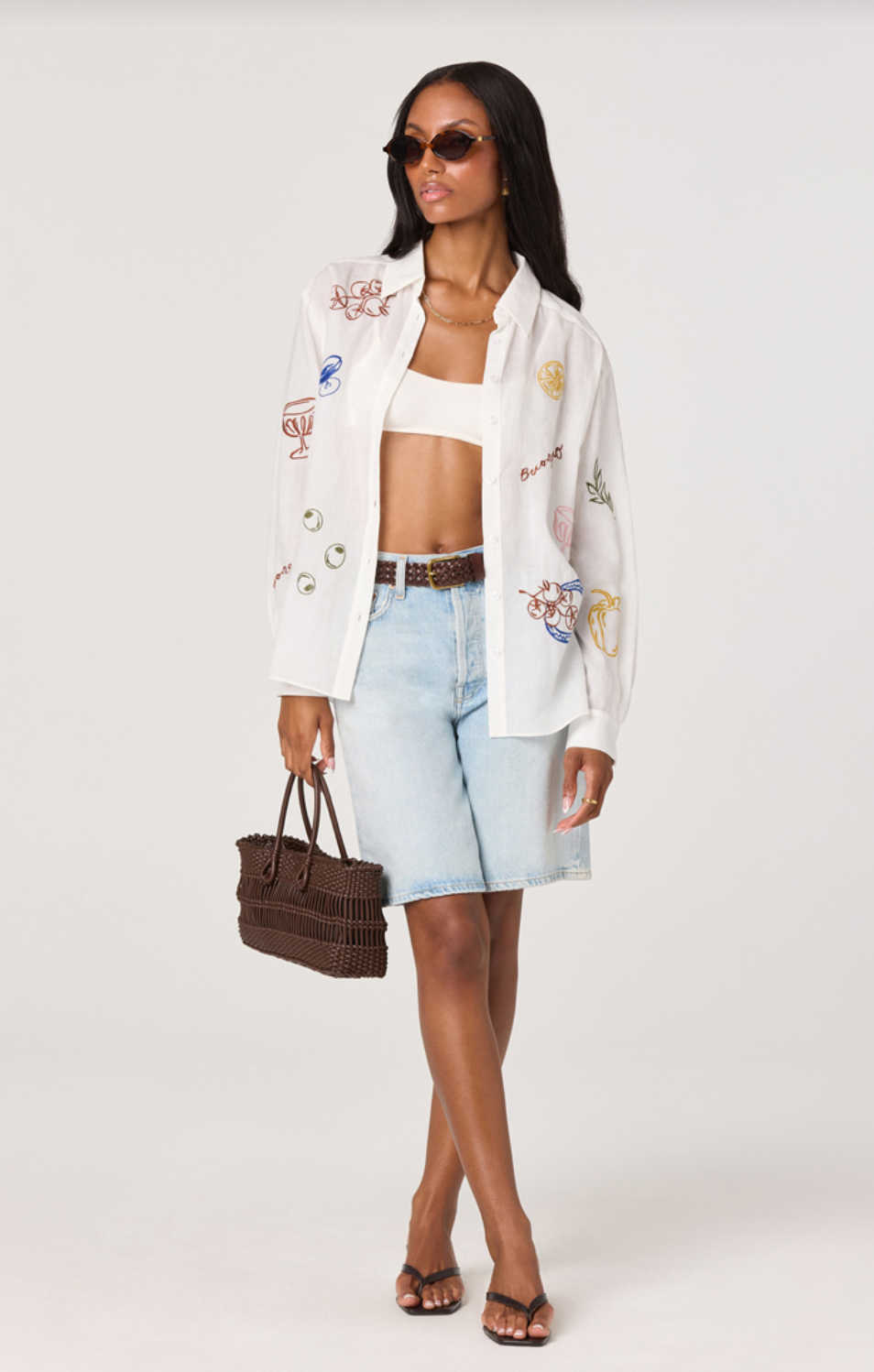ASTR the Label Trace White Picnic Shirt. Woman wearing a white embroidered jacket, white top, light blue shorts, and sunglasses on a white background